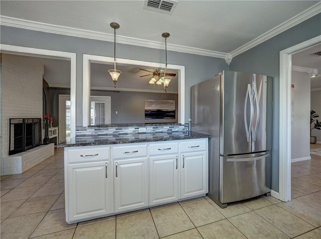 kitchen featuring white cabinets, ceiling fan, hanging light fixtures, and stainless steel refrigerator