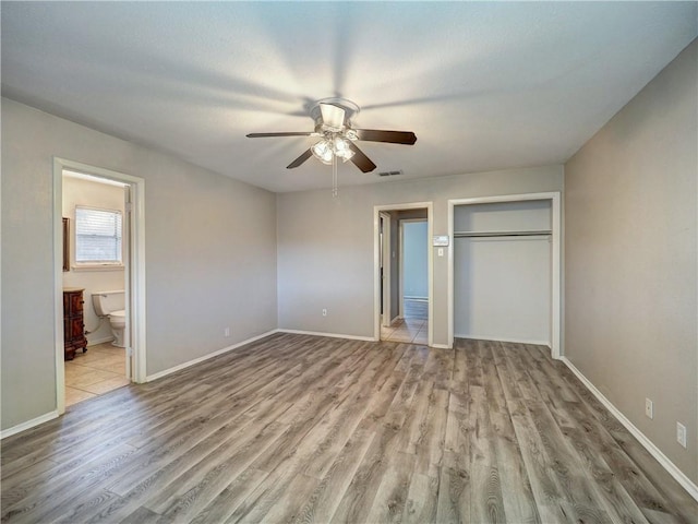 unfurnished bedroom featuring ceiling fan, connected bathroom, and light hardwood / wood-style flooring