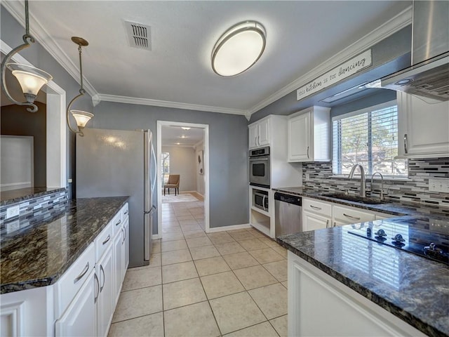 kitchen with appliances with stainless steel finishes, backsplash, sink, pendant lighting, and white cabinets