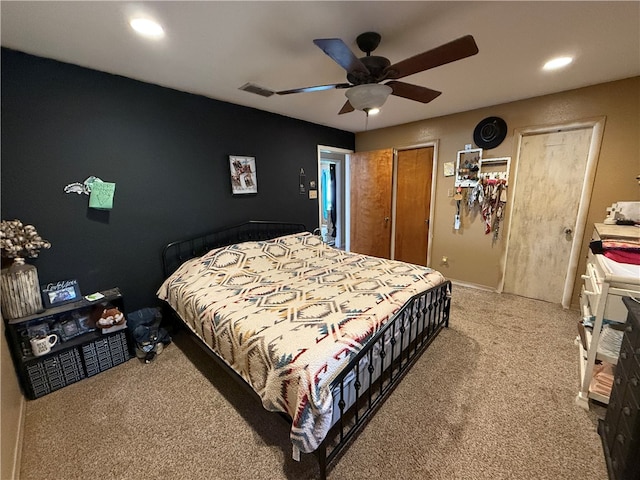 bedroom featuring carpet, ceiling fan, and two closets