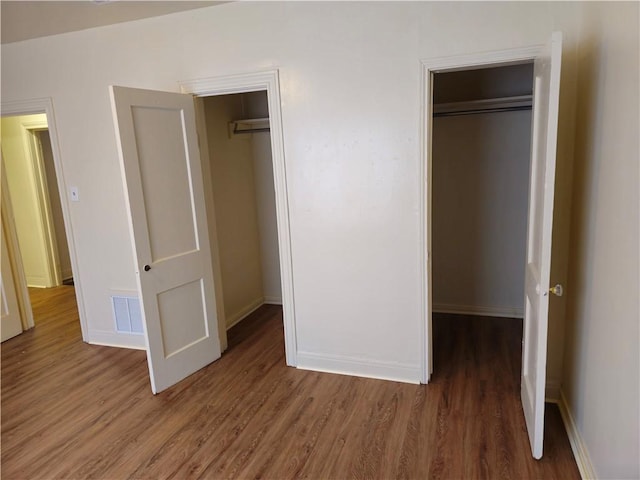 unfurnished bedroom featuring dark wood-type flooring and a closet