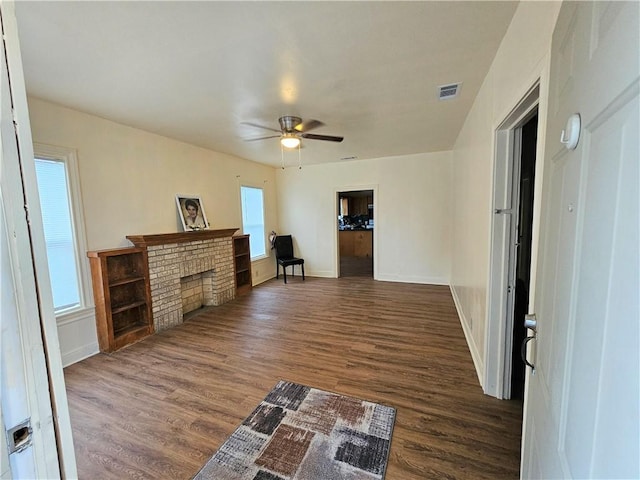 living room with ceiling fan, a fireplace, and dark hardwood / wood-style floors