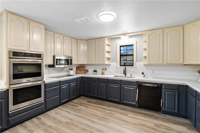 10946 Birdwood, Corpus Christi, TX 78410 - kitchen featuring black appliances, a sink, cream cabinetry, and decorative backsplash