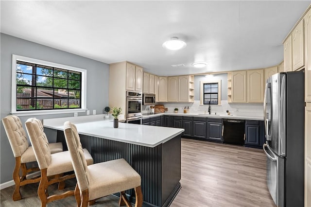 10946 Birdwood, Corpus Christi, TX 78410 - kitchen with stainless steel appliances, a peninsula, light wood finished floors, a breakfast bar, and a sink