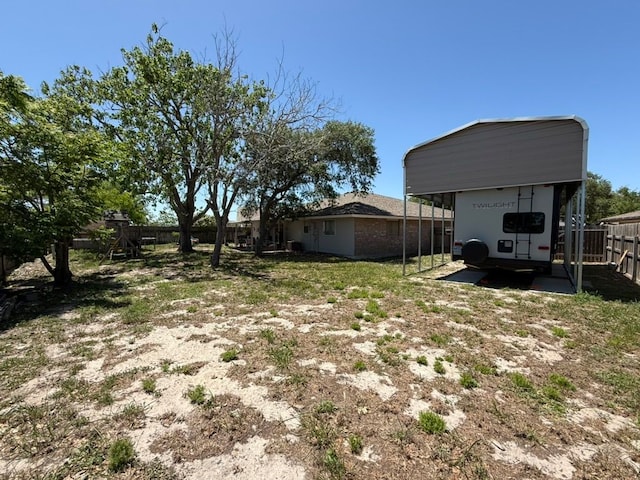 view of yard featuring a carport and fence