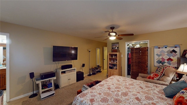 bedroom featuring a closet, visible vents, light carpet, a walk in closet, and baseboards