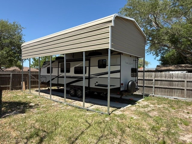 view of outbuilding with a carport and fence