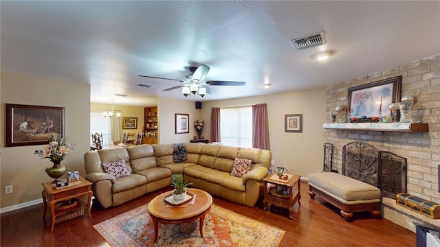 living area featuring visible vents, wood finished floors, and ceiling fan with notable chandelier