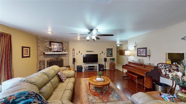living area featuring a brick fireplace, wood finished floors, and ceiling fan