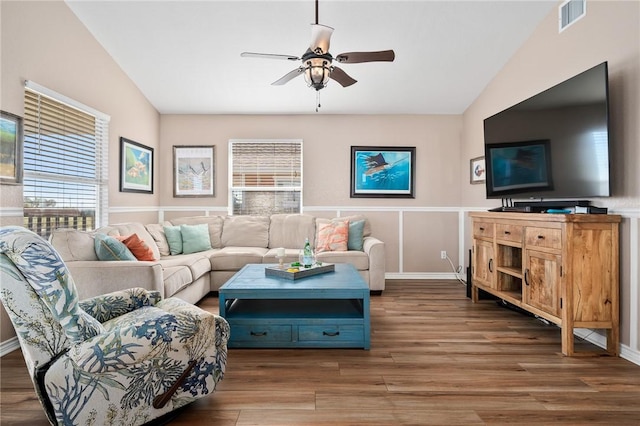 living room with ceiling fan, dark wood-type flooring, and vaulted ceiling