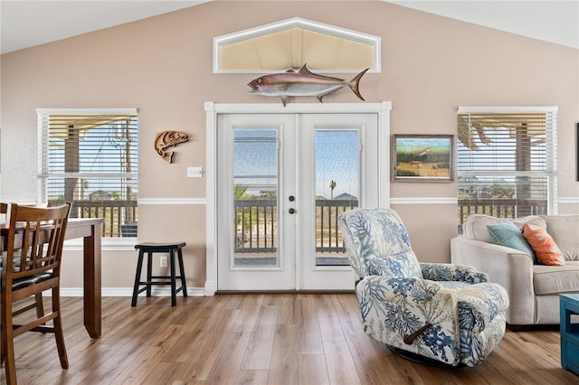 doorway with wood-type flooring, lofted ceiling, and french doors