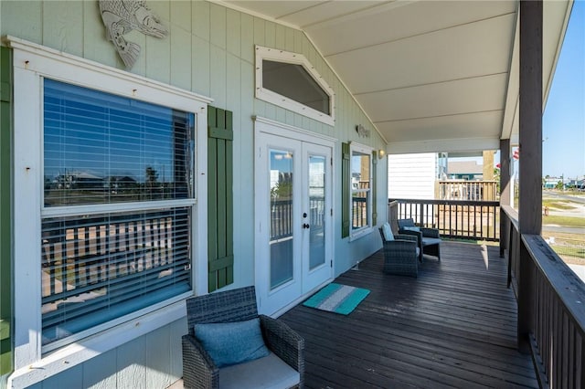 wooden deck featuring covered porch and french doors