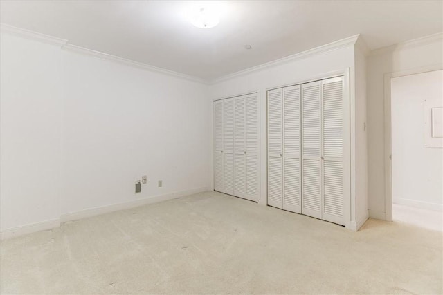 4350 Ocean Dr Unit 103, Corpus Christi, TX 78412 - unfurnished bedroom featuring two closets, baseboards, carpet floors, and crown molding