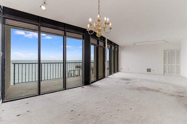 4350 Ocean Dr Unit 103, Corpus Christi, TX 78412 - unfurnished room with carpet floors, expansive windows, a chandelier, a water view, and visible vents