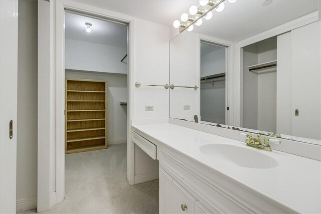 4350 Ocean Dr Unit 103, Corpus Christi, TX 78412 - bathroom featuring a walk in closet, baseboards, and vanity