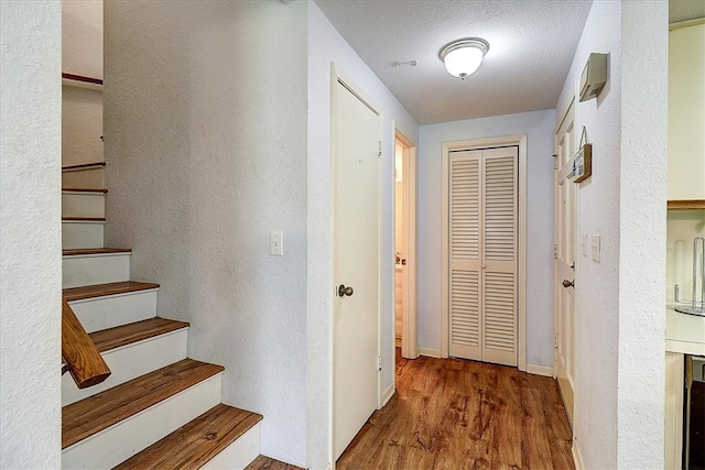 hallway featuring hardwood / wood-style floors and a textured ceiling