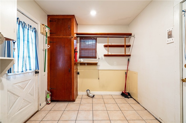 laundry area with light tile patterned floors