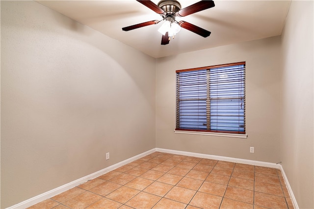 empty room with ceiling fan and light tile patterned floors