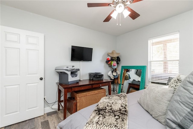 bedroom featuring a ceiling fan, baseboards, and wood finished floors