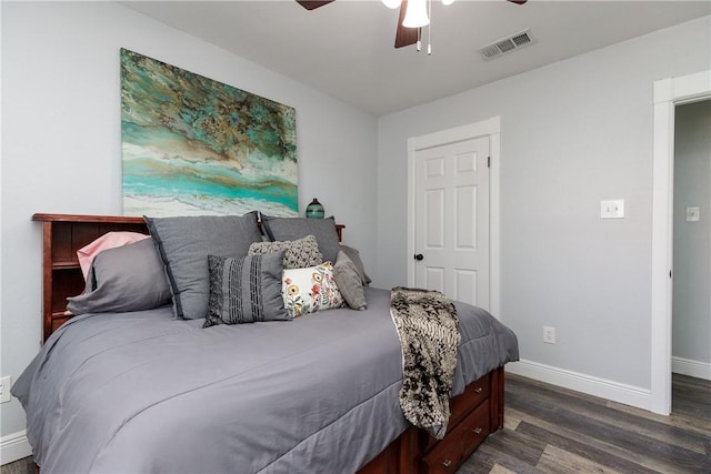 bedroom with ceiling fan, wood finished floors, visible vents, and baseboards