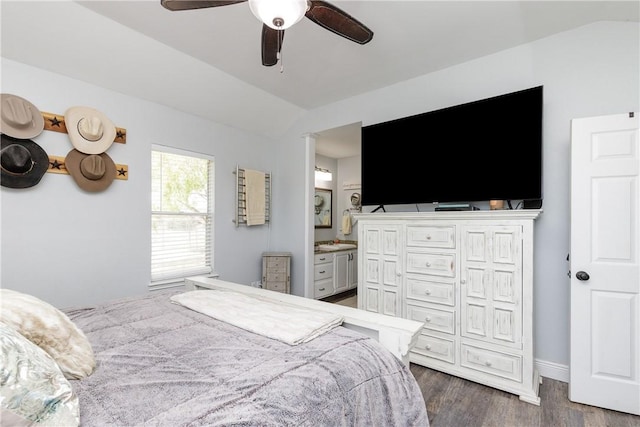 bedroom with baseboards, a ceiling fan, lofted ceiling, dark wood-type flooring, and ensuite bathroom