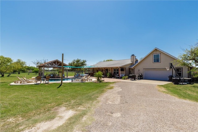 view of front facade featuring a gazebo, a patio area, an outdoor pool, driveway, and a front lawn