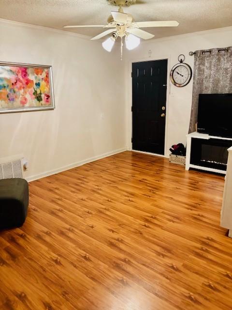 1125 Woodlawn Dr, Corpus Christi, TX 78412 - living room with ceiling fan, a textured ceiling, wood finished floors, and ornamental molding