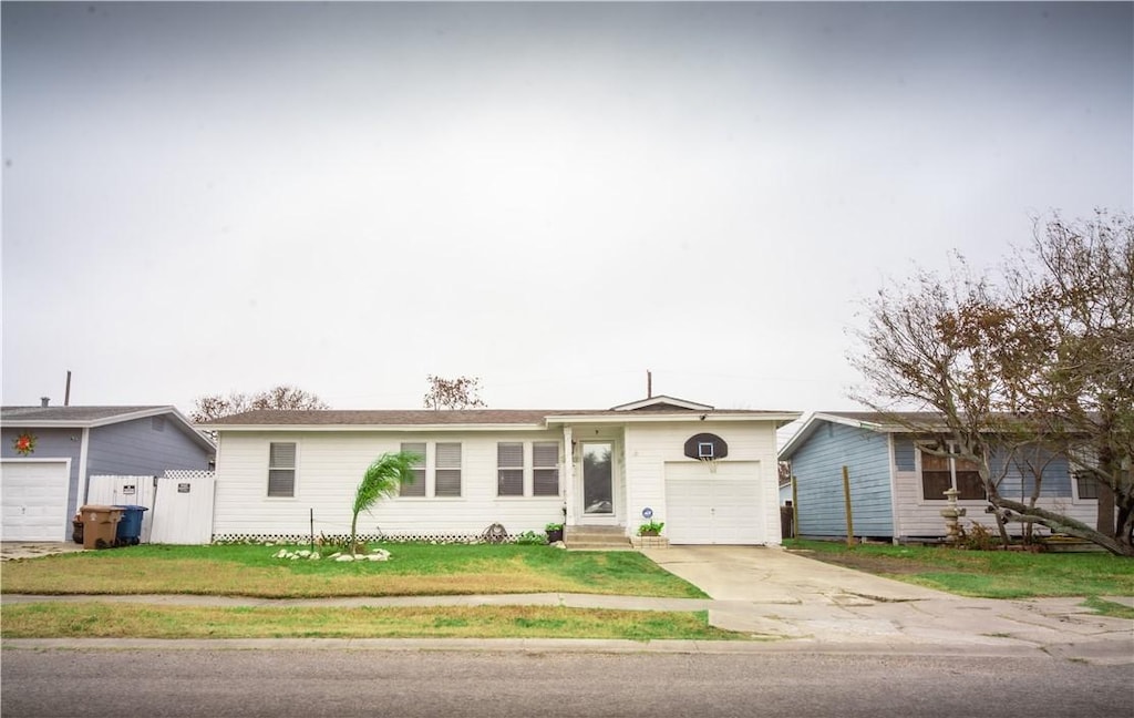 single story home featuring an attached garage, a front lawn, concrete driveway, and entry steps