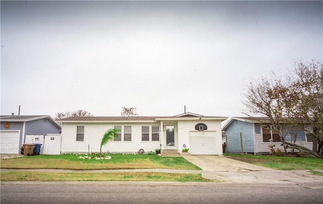 single story home featuring an attached garage, a front lawn, concrete driveway, and entry steps