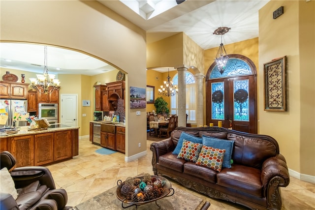 tiled living room with a high ceiling, an inviting chandelier, sink, and french doors