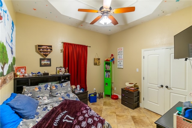 bedroom with light tile patterned flooring, ceiling fan, and a closet