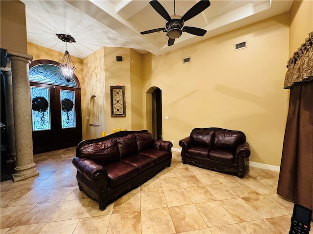 tiled living room with a high ceiling, ceiling fan, ornate columns, and french doors