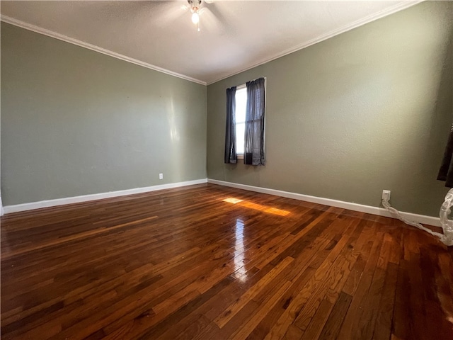 empty room with dark hardwood / wood-style flooring and crown molding