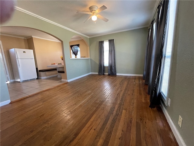 empty room with light hardwood / wood-style flooring, ceiling fan, and ornamental molding