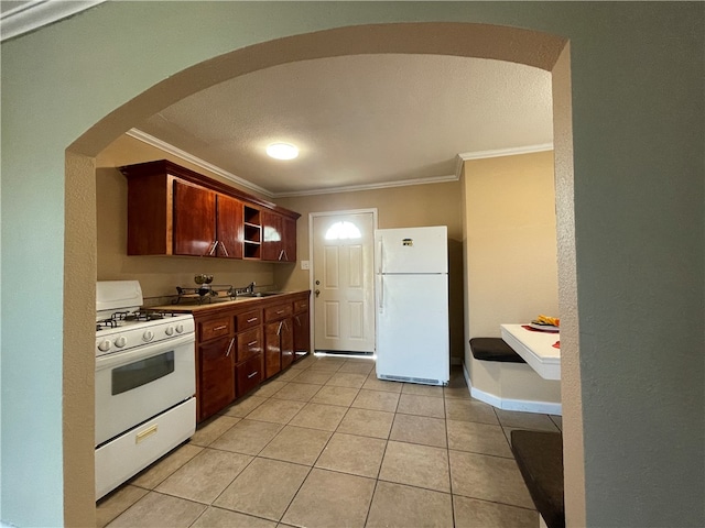 kitchen featuring light tile patterned floors, white appliances, ornamental molding, and sink