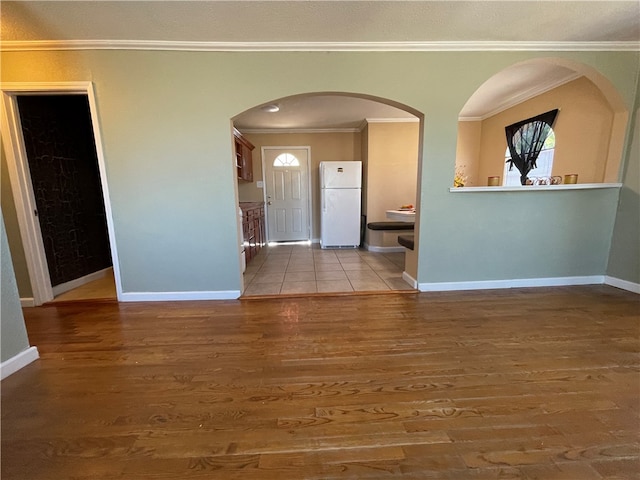 entrance foyer with light hardwood / wood-style flooring and crown molding