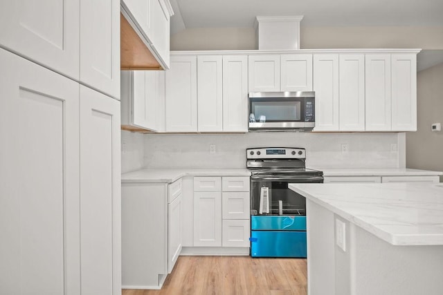kitchen with light wood-style flooring, white cabinets, tasteful backsplash, and stainless steel appliances