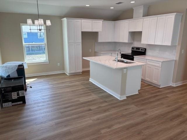 kitchen featuring black / electric stove, white cabinetry, sink, and a kitchen island with sink