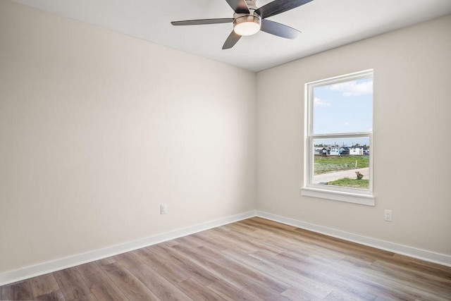 spare room featuring baseboards, ceiling fan, and wood finished floors
