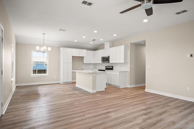 kitchen featuring appliances with stainless steel finishes, ceiling fan with notable chandelier, open floor plan, and visible vents
