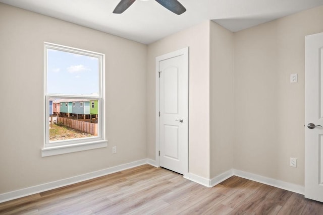 unfurnished bedroom with a ceiling fan, baseboards, and light wood-style floors