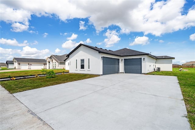 view of front of home featuring central AC unit, a garage, and a front yard