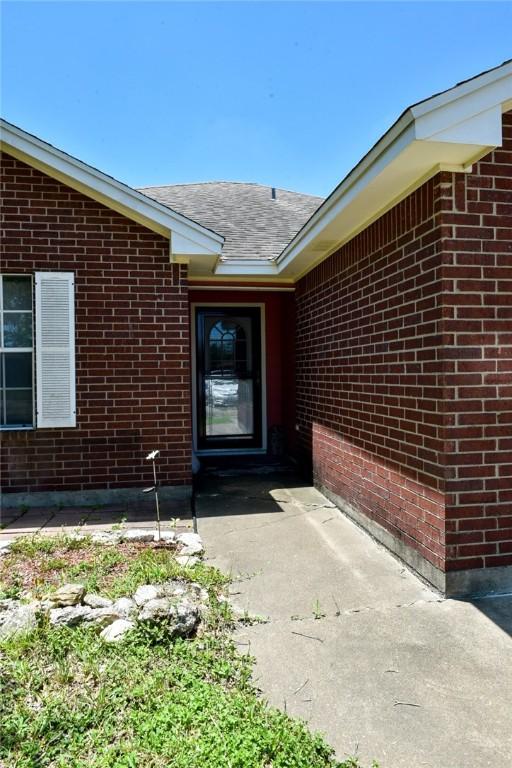 305 Hickory Ct, Bishop, TX 78343 - property entrance with brick siding and a shingled roof