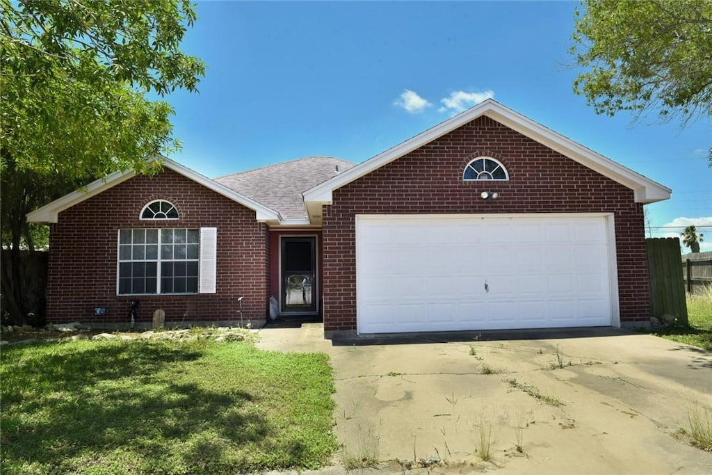 305 Hickory Ct, Bishop, TX 78343 - ranch-style house with concrete driveway, brick siding, and an attached garage