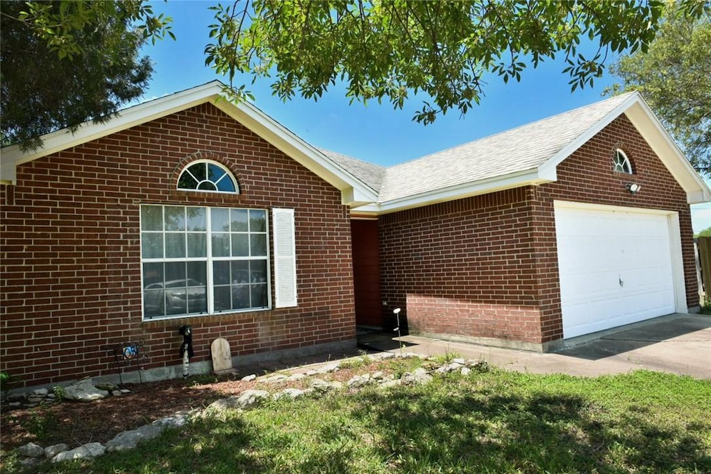 305 Hickory Ct, Bishop, TX 78343 - ranch-style home featuring brick siding, a garage, driveway, and a shingled roof