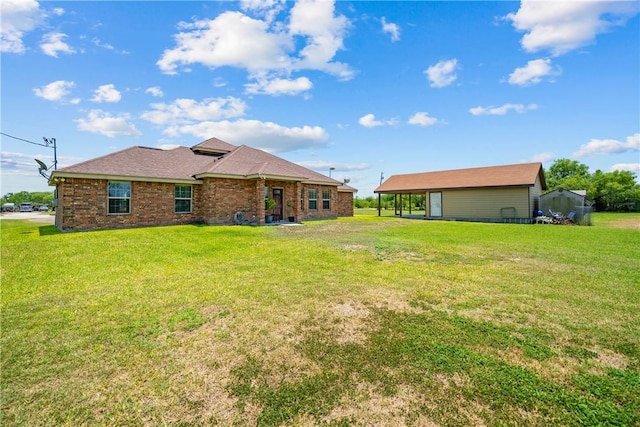 3941 Cobb Ln, Robstown, TX 78380 - back of house with a yard, brick siding, and a carport
