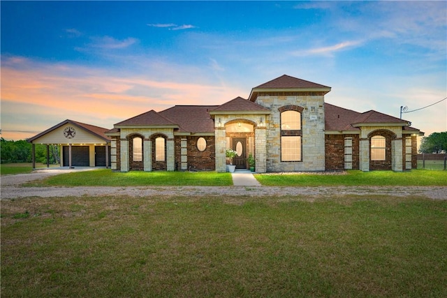 3941 Cobb Ln, Robstown, TX 78380 - view of front facade with a yard, gravel driveway, stone siding, and a carport