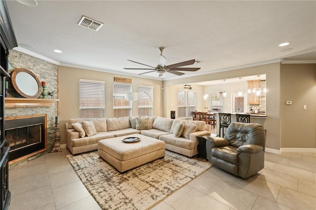 living area with ornamental molding, plenty of natural light, a fireplace, and visible vents