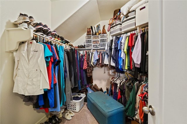 walk in closet featuring carpet floors and vaulted ceiling