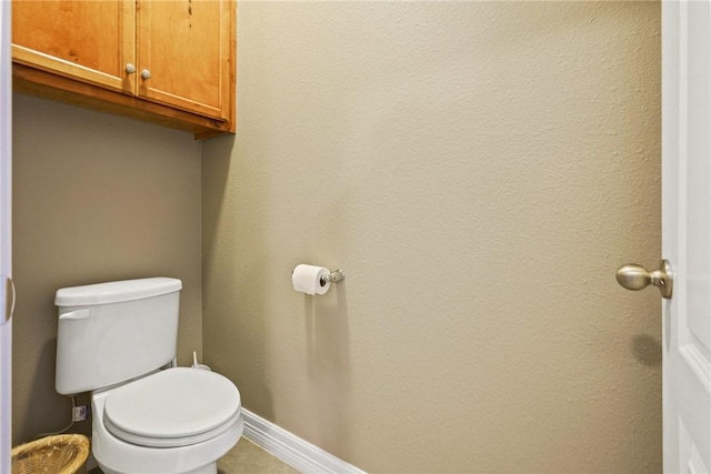 bathroom featuring toilet and baseboards